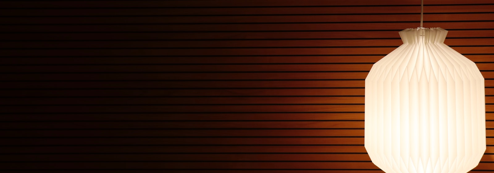 Warm pendant lamps glowing against a dark wall