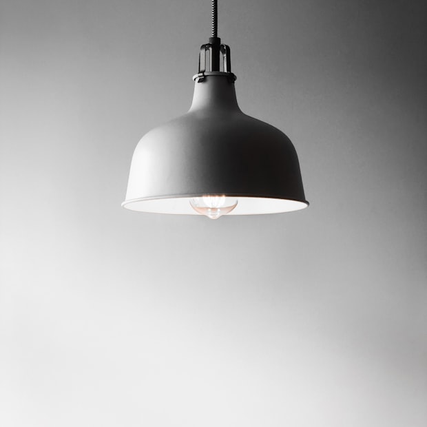 A wide white pendant lamp lit from within