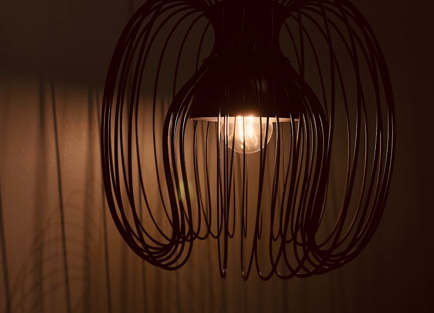 A wire cage chandelier lit from the centre